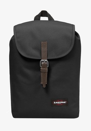 Czarny plecak Eastpak z brązowym paskiem z klamrą ze skóry i górną rączką, logo umieszczone na dole z przodu po prawej stronie.