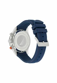 Reloj Nautica con caja de acero inoxidable, correa de silicona azul marino, superficie texturizada y botón de acento naranja. Diseño resistente al agua.
