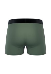 Un caleçon vert en tissu lisse avec une ceinture noire. Le short a une coupe ajustée et un minimum de détails, principalement uni.
