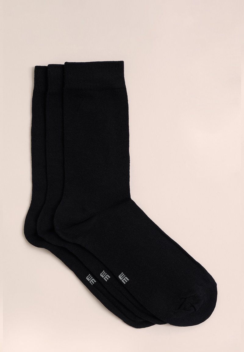 Schwarze Baumwollsocken, drei Paar, glatte Textur, gerippte Bündchen und verstärkte Fersen. Mit kleinem grauen Logo in der Nähe der Zehen.