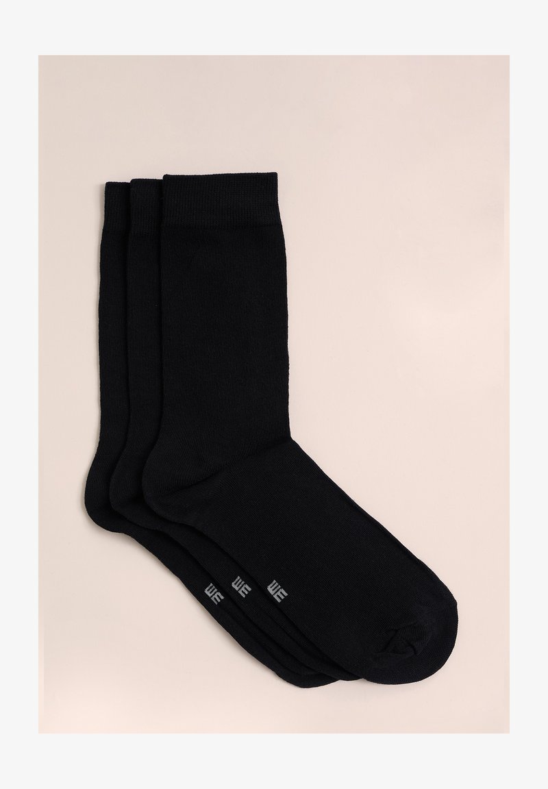 Juodos medvilnės kojinės, trys poros, lygus paviršius, sustiprinti kraštai, ir sutvirtinti kulnai. Ant pirštų yra mažas pilkas prekės ženklas.