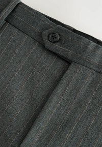 Grau gestreifter Stoff mit einem Knopfverschluss am Bund; weiche Textur mit subtilen Nähten in kontrastierenden Farben.