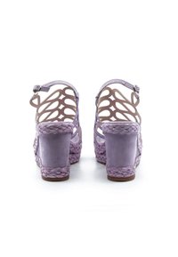 Sandali wedge lavanda con trama intrecciata e design a taglio. Chiusura con fibbia alla caviglia. Materiale morbido con tacco impilato.