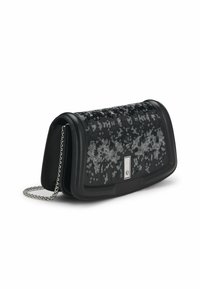 Musta nahkakotelo hopeisilla paljeteilla etuläpällä ja hopeisella ketjuolkaimella, kulmakuva valkoista taustaa vasten.