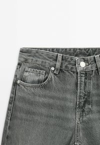 Jeans in denim grigio con vita alta, design tradizionale a cinque tasche e classica chiusura con bottone, caratterizzati da una leggera texture distressed.
