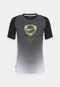 Czarna i biała sportowa koszulka z krótkim rękawem, z gradientowym wzorem z kropek, z żółtym logo Nike na środku i siateczkowymi wstawkami.