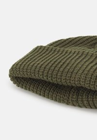 Olivgrüner Strickbeanie mit gerippter Textur, am Boden umgeschlagen, aus einem weichen und warmen Wollmischmaterial gefertigt.
