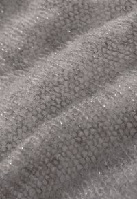 Szara dzianina o miękkiej strukturze, z delikatnym połyskiem. Splot ma lekko luźny wzór z cienkimi, błyszczącymi metalicznymi nitkami.