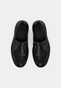 Musta nahka loafers, joissa on fringed-koriste ja ompeluyksityiskohtia. Pyöreä kärki ja sileä pinta pehmustetulla sisäpohjalla.