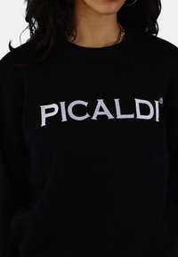 Black sweatshirt made of soft fabric featuring white embroidered "PICALDI" logo across the chest. Classic crew neck design.