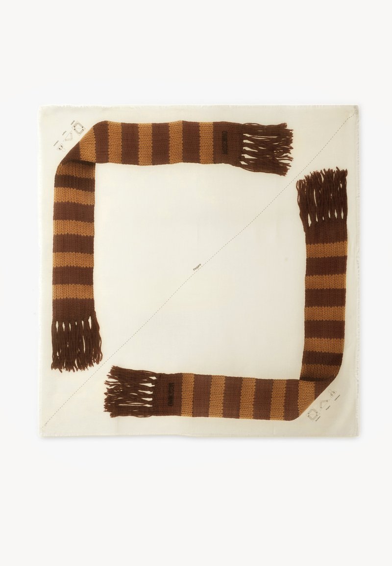 Écharpe tricotée rayée marron et beige avec des extrémités à franges, disposée en diagonale sur un fond en tissu blanc carré.