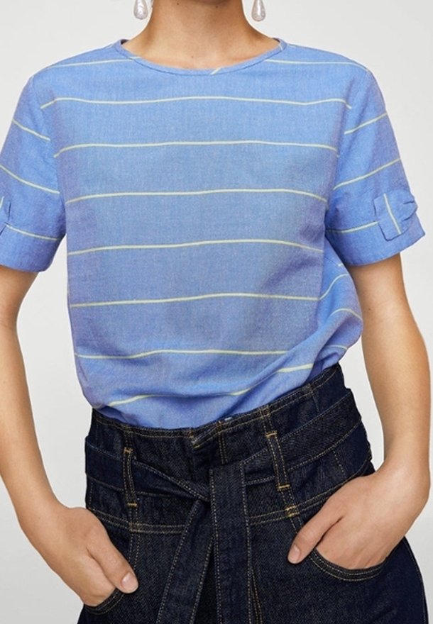 Chemise à rayures bleues à manches courtes, en tissu léger. Présente de fines rayures jaunes et un col rond, associée à un pantalon en denim foncé.