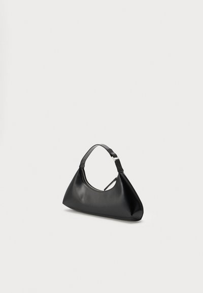 Petit sac à main en cuir noir avec une seule poignée et une fermeture éclair visible sur le dessus, présenté sur un fond clair uni.