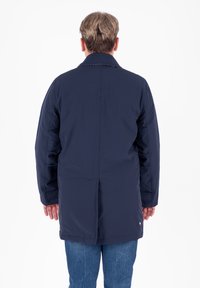 Giacca impermeabile blu navy con colletto classico, maniche lunghe e taglio dritto. Presenta cuciture sottili e tasche laterali.