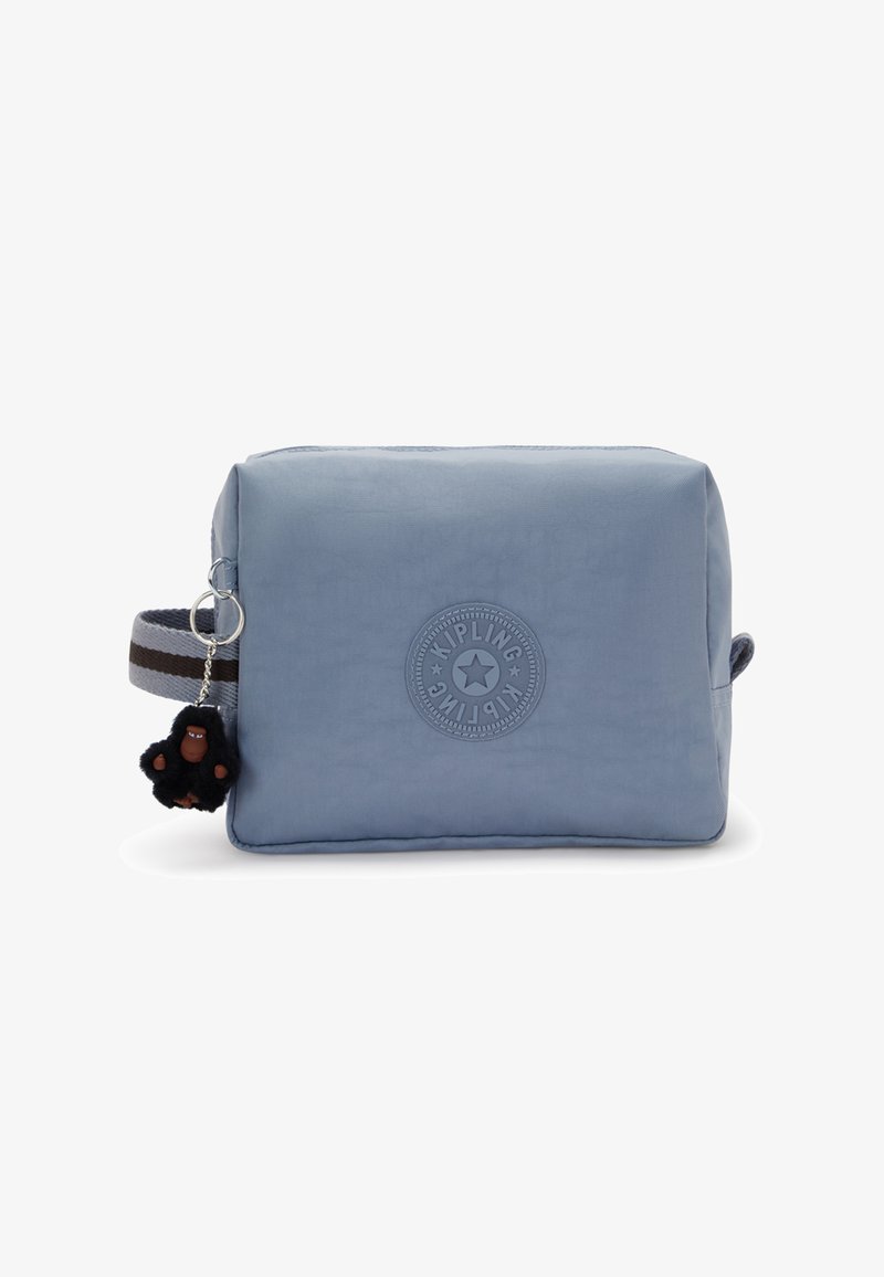 Blauwe stoffen tas met een rond Kipling-logo, een afneembare zwarte harige aap sleutelhanger en een gestreepte schouderband.