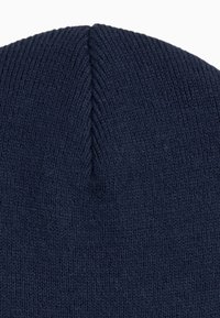 Marineblå strikket beanie med en blød tekstur, der har en afsmalnet top og et glat, sammenhængende mønster gennem hele stoffet.