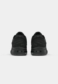 Black athletic shoes featuring a cushioned sole, textured upper, and distinctive branding on the heel and side, designed for comfort and support.