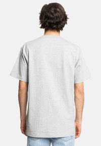 Grå bomulds t-shirt med korte ærmer og klassisk rund halsudskæring, med en afslappet pasform og glat tekstur, set fra bagsiden.