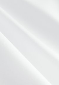 Tessuto bianco con una texture liscia, caratterizzato da una leggera lucentezza e pochissime pieghe, drappeggiato diagonalmente per creare profondità e dimensione.