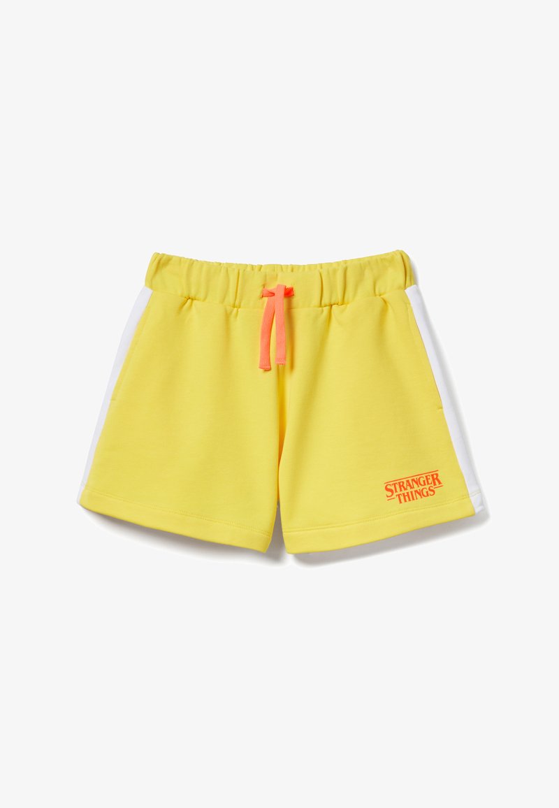 Pantaloncini con vita elastica gialla con strisce laterali bianche, coulisse rosa e piccolo logo arancione "Stranger Things" sulla gamba sinistra.