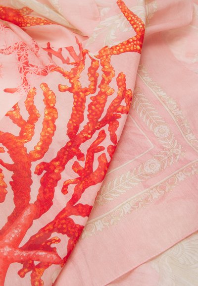 Koralo rašto šalikas su ryškiomis raudonomis ir oranžinėmis spalvomis ant šviesiai rožinio fono, su gėlių akcentais ir švelniu, lengvu tekstūra.