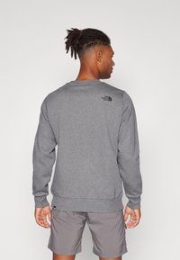 Grijze sweatshirt met lange mouwen, gemaakt van een katoenmix, met ribgebreide manchetten en zoom, voorzien van een klein zwart logo boven de linkerschouder.