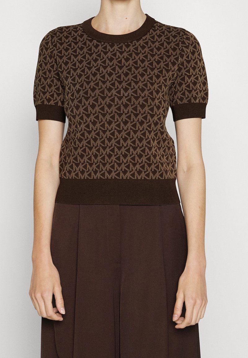 Camisa de punto marrón con un diseño de patrón geométrico en marrón claro, mangas cortas acampanadas y un cuello redondo y dobladillo acanalados.