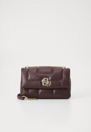 Borsa a tracolla trapuntata in pelle marrone scuro con catena dorata e chiusura con doppia lettera dorata sul flap anteriore, su sfondo bianco.