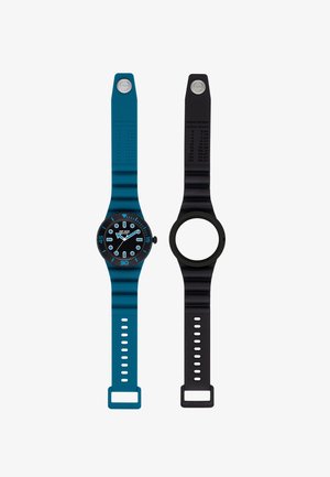 Deux bracelets en silicone rayés côte à côte ; à gauche avec un cadran de montre noir et bleu, à droite avec un cadre de montre noir vide.