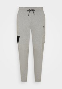 Šedé tepláky s elastickým pasem a šňůrkou, bočními kapsami a černým akcentem na nohavici. Logo Nike na levém stehně.