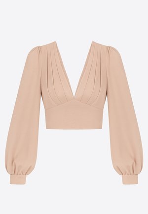 Haut court à manches bouffantes en beige clair, avec un décolleté en V profond, un corsage plissé et des poignets élastiques pour une coupe structurée. Texture de tissu lisse.