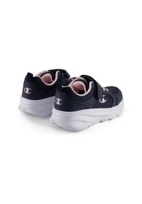 Granatowe buty sportowe z różowymi akcentami, charakteryzujące się teksturowaną cholewką, zapięciem na rzep oraz amortyzującą białą podeszwą. Logo widoczne na pięcie.