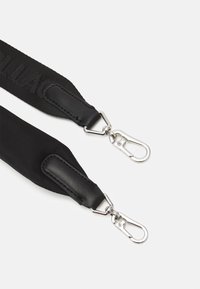 Czarny regulowany pasek wykonany z trwałej tkaniny z skórzanymi detalami. Wyposażony w metalowe zapięcia do mocowania, o gładkiej fakturze i dyskretnym logo.