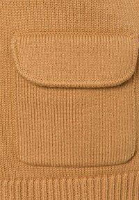 Gestrickter Pullover in warmem Tan mit gerippter Struktur. Verfügt über eine große aufgesetzte Tasche auf der Vorderseite und eine leicht oversized Passform.