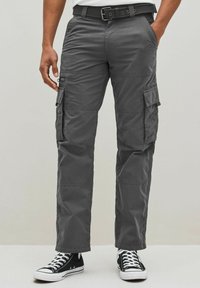 Gray cargo pants with multiple side pockets, a belt with a metal buckle, straight legs, and a lightweight fabric. Worn with black sneakers.
