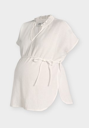 Weiße strukturierte Umstandsbluse mit kurzen Ärmeln, gerafftem V-Ausschnitt und Taillengürtel auf hellem Hintergrund.