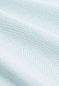 Tissu bleu clair avec une texture côtelée subtile, affichant des plis doux et lisses. Le matériau semble léger et respirant.