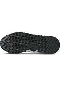 Rubber shoe outsole with a wavy tread pattern. Predominantly black with subtle gray accents near the heel. Textured for grip and durability.
