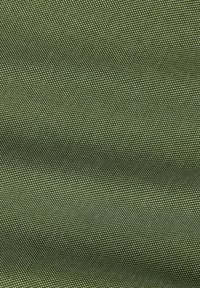 Gros plan d'un tissu vert texturé avec un motif tissé serré créant de petites bosses élevées uniformes sur toute la surface.
