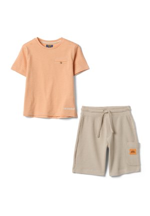 Camiseta de manga corta a rayas naranjas y blancas con bolsillo en el pecho y pantalones cortos beige con textura, cordón y parche en el bolsillo lateral.