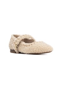 Zapato estilo Mary Jane en color beige, hecho de un material texturizado y esponjoso. Presenta una correa en forma de cruz con acentos dorados y una suela pequeña y plana.