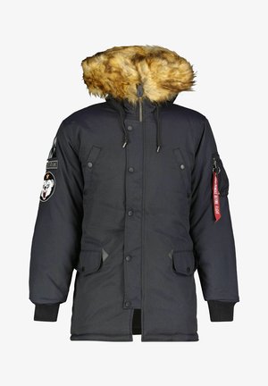 Schwarze Parka mit Kunstfellbesatz an der Kapuze, mit Druckknöpfen, seitlichen Taschen und einer seitlichen Armtasche mit einem roten Etikett mit der Aufschrift "Vor dem Flug entfernen."