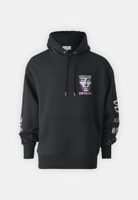 Hoodie preto com um design gráfico frontal apresentando uma máscara. Inclui um bolso canguru e capuz com cordão. Realçado com texto branco nas mangas.