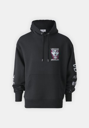 Μαύρη φούτερ με γραφικό σχέδιο μπροστά που απεικονίζει μία μάσκα. Περιλαμβάνει καγκουρό τσέπη και κουκούλα με κορδόνι. Διακοσμημένη με λευκό κείμενο στις μανίκες.