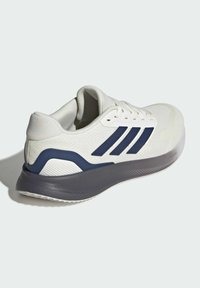 Zapatilla deportiva blanca con franjas marinas. Parte superior de malla, suela acolchada, agarre de goma y detalle texturizado en el talón. Diseño de silueta curvada.