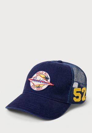 Marineblåt kasket med netbagside, med et mærke hvor der står "Polo RL Beach Club Est 1967" og gul "52" på siden.