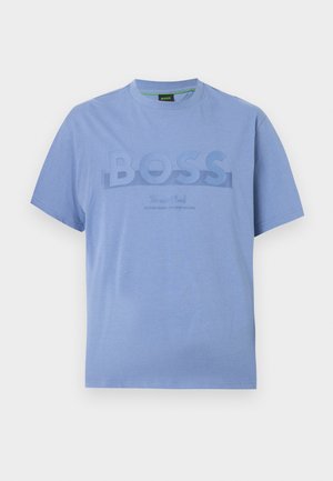 Ανοιχτό μπλε κοντομάνικο T-shirt με στρογγυλή λαιμόκοψη, μεγάλο ανάγλυφο λογότυπο "BOSS" στο μπροστινό μέρος και μικρότερο κείμενο από κάτω, σε απλό φόντο.