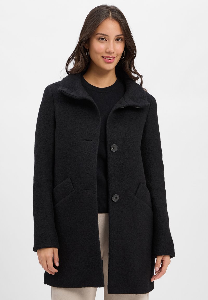 Black wool blend coat with a button closure, wide collar, and two front pockets. Smooth texture and tailored fit. Subtle design details.