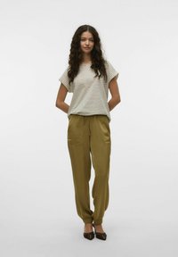 T-shirt boxy à rayures crème et marron associé à un pantalon tapered vert olive comportant deux poches avant et des poignets élastiqués.