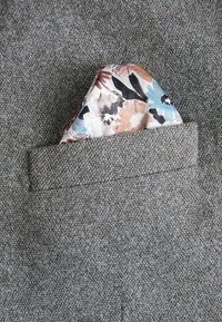 Grau strukturiertes Jackenmaterial mit einem sichtbaren Einstecktuch, das florale Muster in Blau-, Orange- und Beigetönen zeigt.
